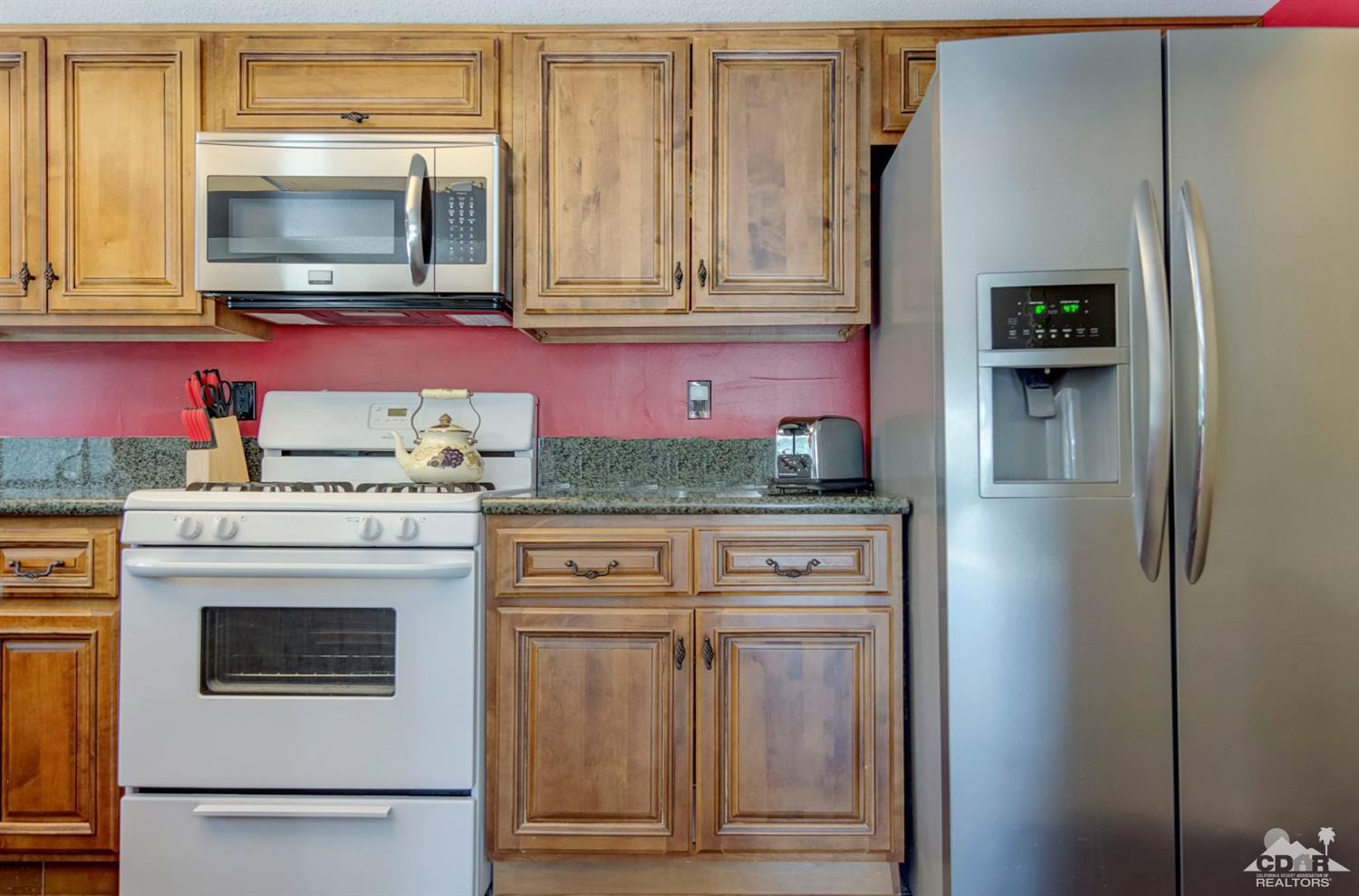 73769 Haystack Road Palm Desert, CA 92260 - Photo 20 of 34 a kitchen with stainless steel appliances granite countertop a refrigerator and a stove top oven