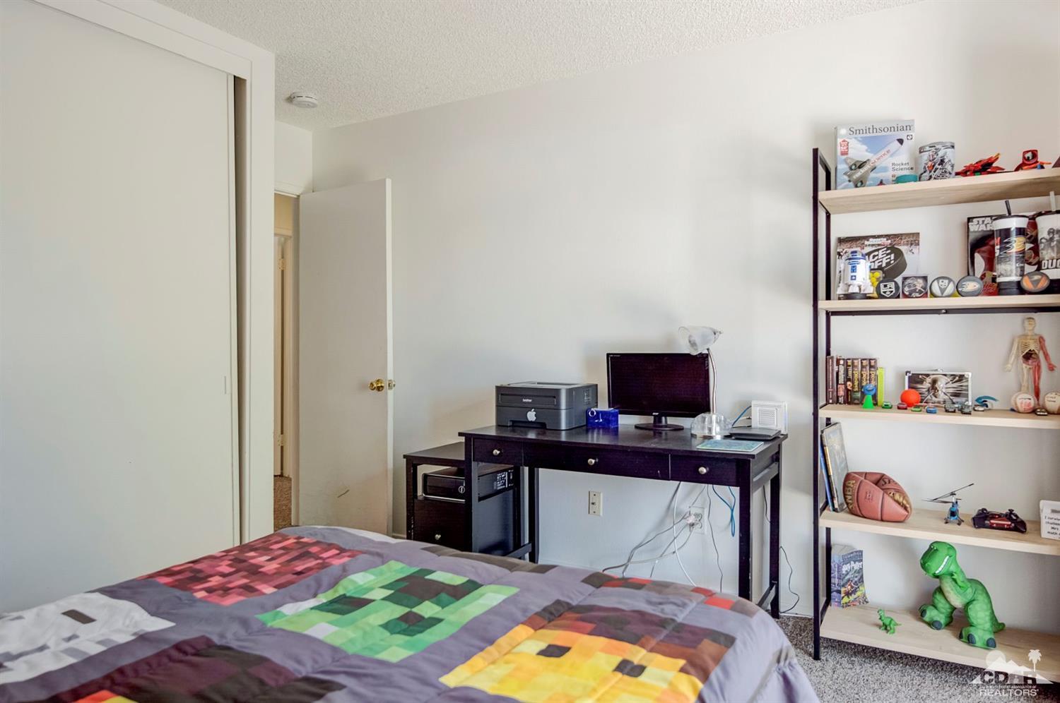73769 Haystack Road Palm Desert, CA 92260 - Photo 24 of 34 a bedroom with a bed and a flat screen tv