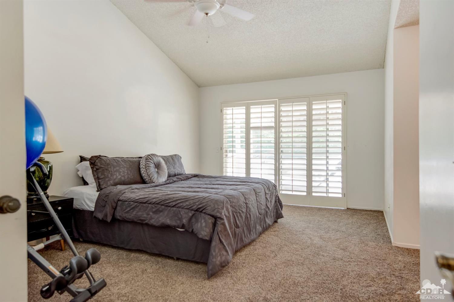 73769 Haystack Road Palm Desert, CA 92260 - Photo 29 of 34 a spacious bedroom with a bed a table and chair