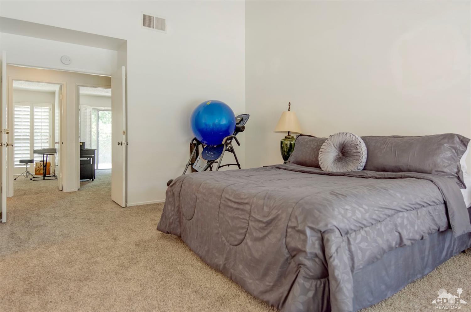 73769 Haystack Road Palm Desert, CA 92260 - Photo 31 of 34 a bedroom with a bed and a chandelier