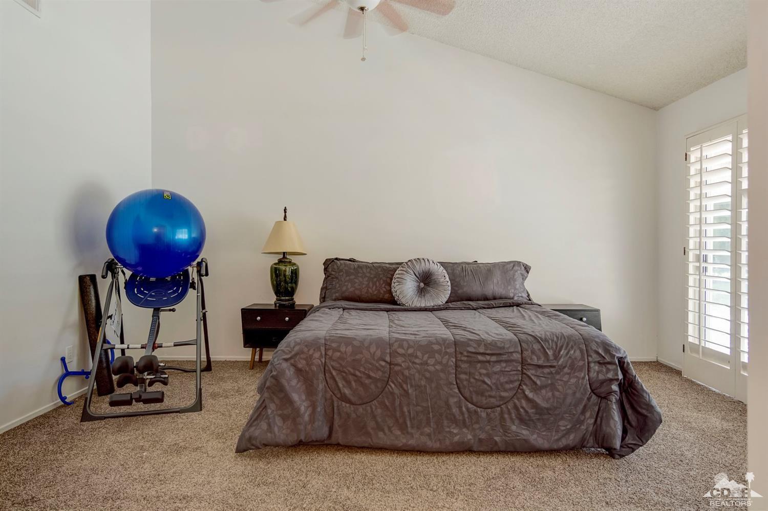 73769 Haystack Road Palm Desert, CA 92260 - Photo 32 of 34 a bedroom with a bed and a chandelier
