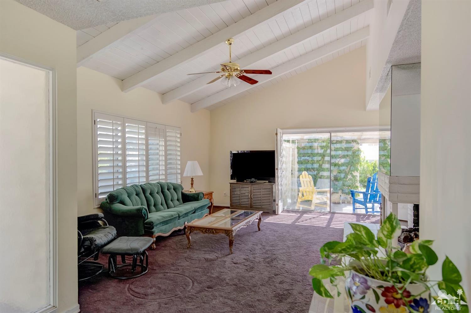 73769 Haystack Road Palm Desert, CA 92260 - Photo 9 of 34 a living room with furniture a flat screen tv and a large window