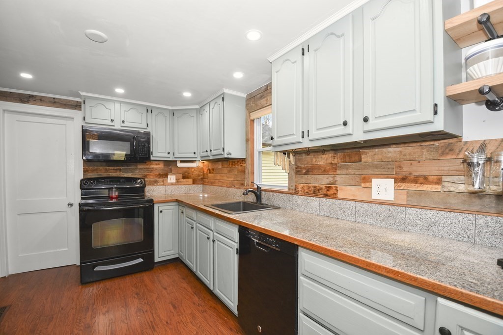 22 Carleton Road Leicester, MA 01542 - Photo 6 of 28 a kitchen with granite countertop a sink stainless steel appliances and white cabinets
