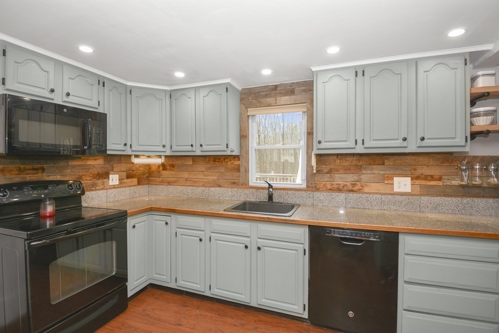 22 Carleton Road Leicester, MA 01542 - Photo 7 of 28 a kitchen with granite countertop a sink white cabinets stainless steel appliances and a sink