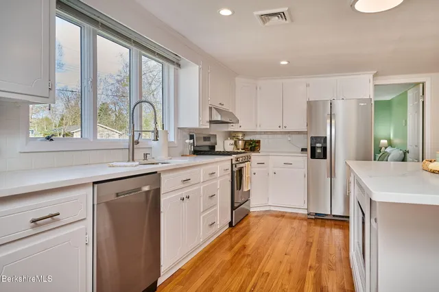 a kitchen with white cabinets and white appliances