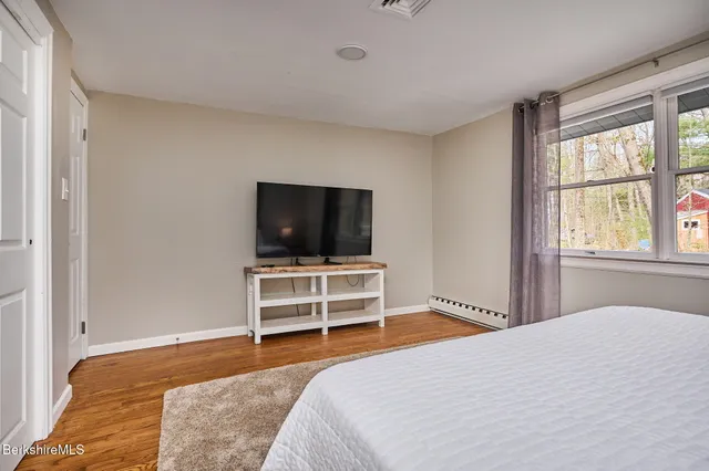 a bedroom with a bed and a flat screen tv