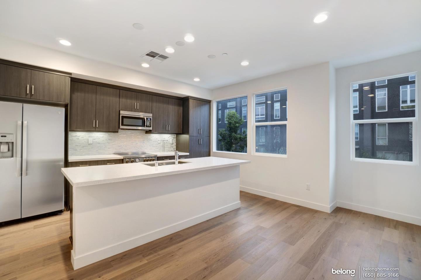 1351 Pullman Way Oakland, CA 94607 - Photo 18 of 24 a kitchen with stainless steel appliances granite countertop a refrigerator a sink dishwasher a stove and a refrigerator with wooden floor