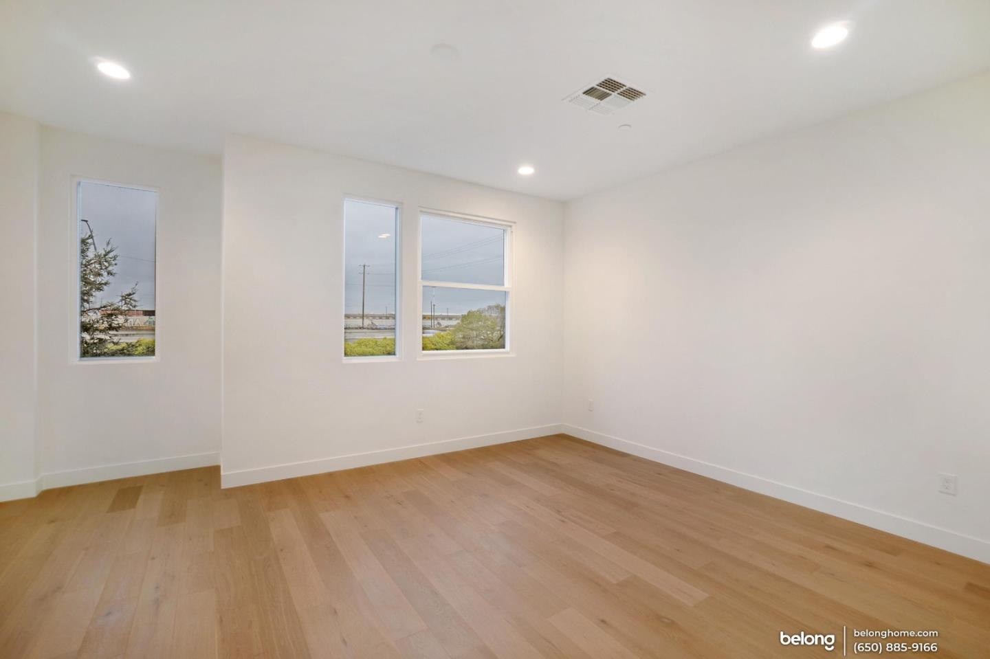 1351 Pullman Way Oakland, CA 94607 - Photo 4 of 24 an empty room with wooden floor and windows
