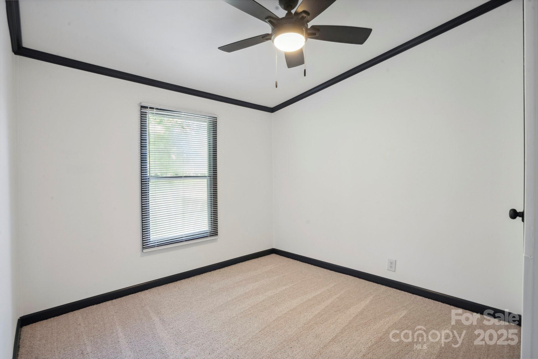 6085 Faith Road Salisbury, NC 28146 - Photo 6 of 29 an empty room with a window and a ceiling fan