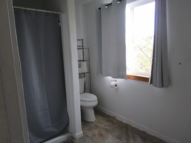 89-902 Rd Road Captain Cook, HI 96704 - Photo 11 of 30 a bathroom with a toilet and a shower curtain