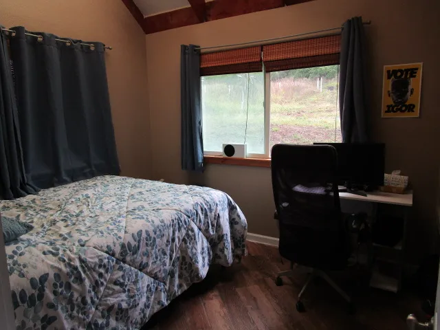 a bedroom with a bed and wooden floor