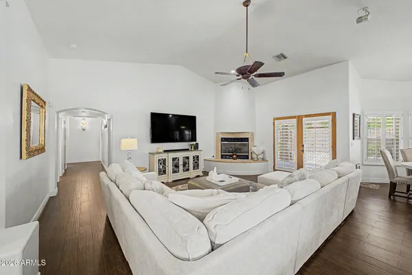 a living room with furniture a ceiling fan and a flat screen tv