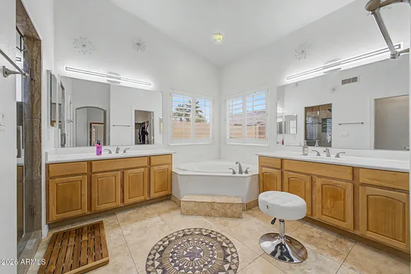 a spacious bathroom with a double vanity sink a mirror and a bathtub