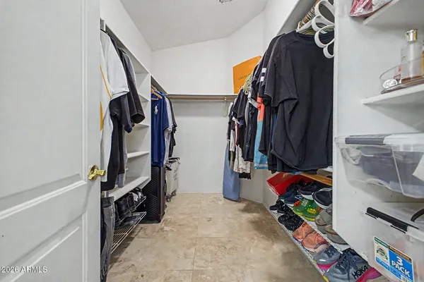 a view of walk in closet with clothes and shoes