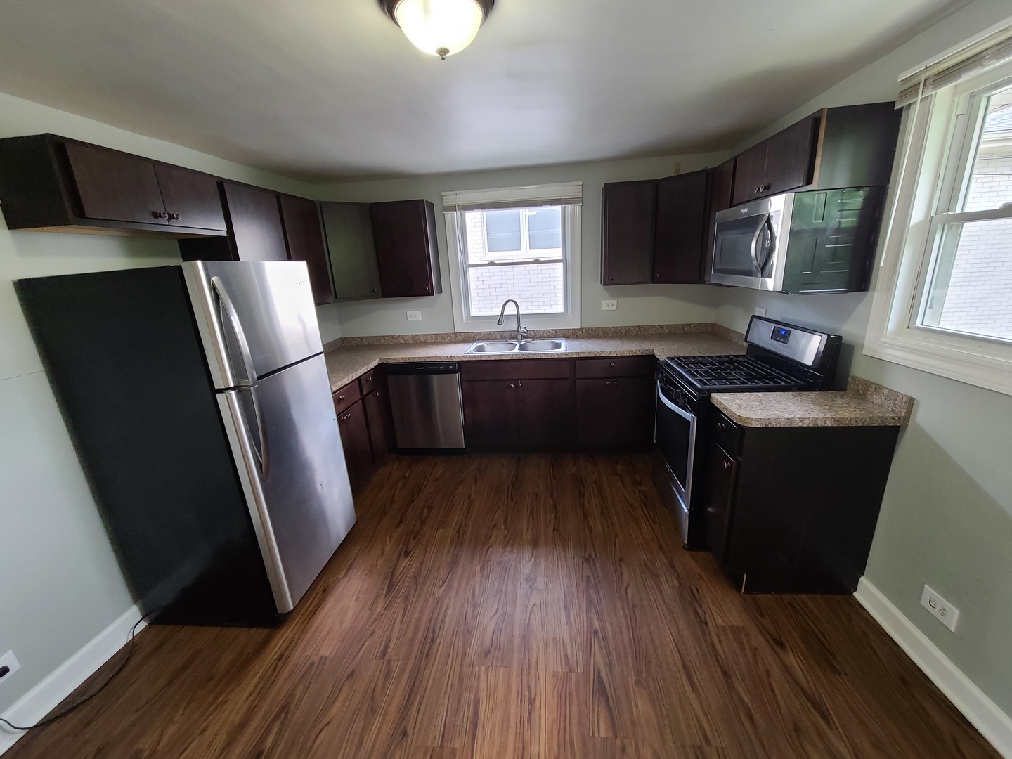 11032 Major Avenue Chicago Ridge, IL 60415 - Photo 4 of 10 a kitchen with granite countertop a refrigerator a sink dishwasher a stove and white countertops with wooden floor