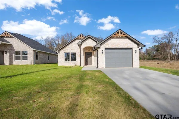 a view of a yard in front of a house with large trees