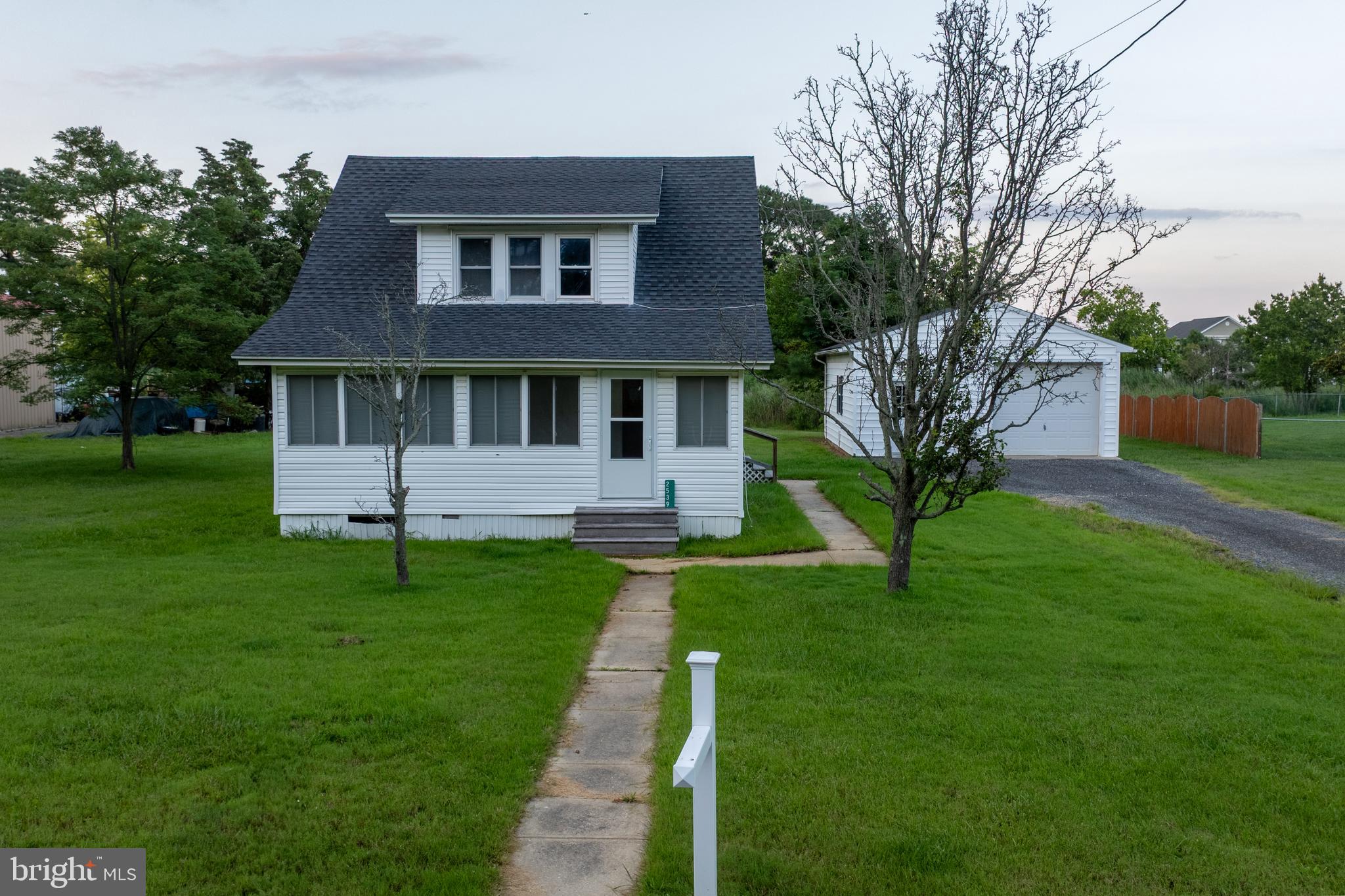 a front view of a house with a yard and trees