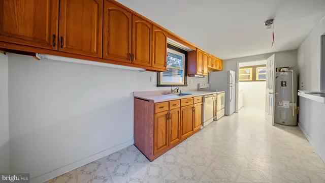 a kitchen with stainless steel appliances granite countertop a stove a refrigerator and a sink with cabinets