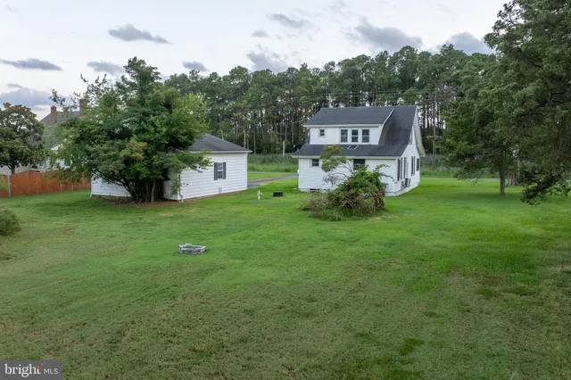 a view of a big house with a big yard and large trees