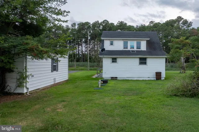a backyard of a house with wooden fence and a tree