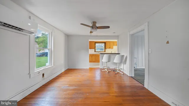 an empty room with windows and a chandelier fan