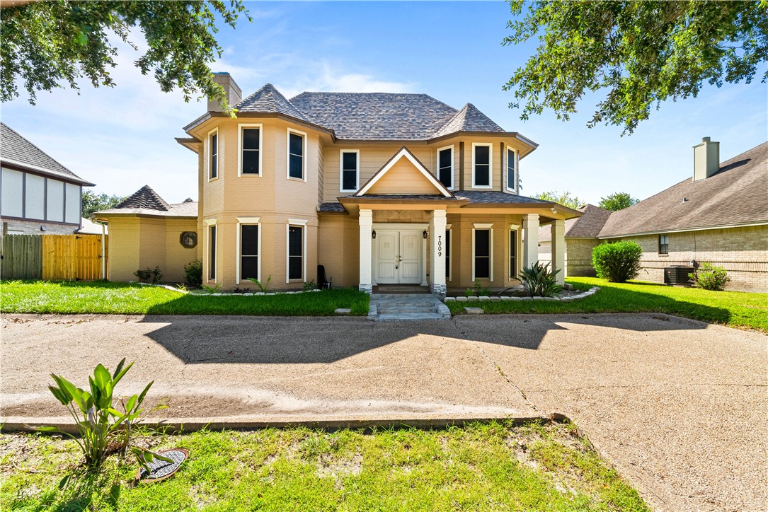 a front view of a house with a garden and yard