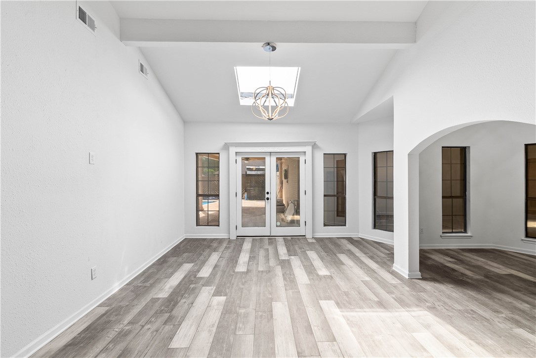 7009 Bevington Drive Corpus Christi, TX 78413 - Photo 14 of 34 a view of a room with wooden floor a ceiling fan and windows