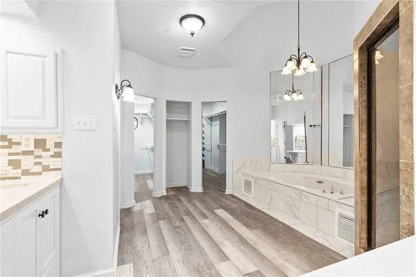 a bathroom with a tub sink and mirror