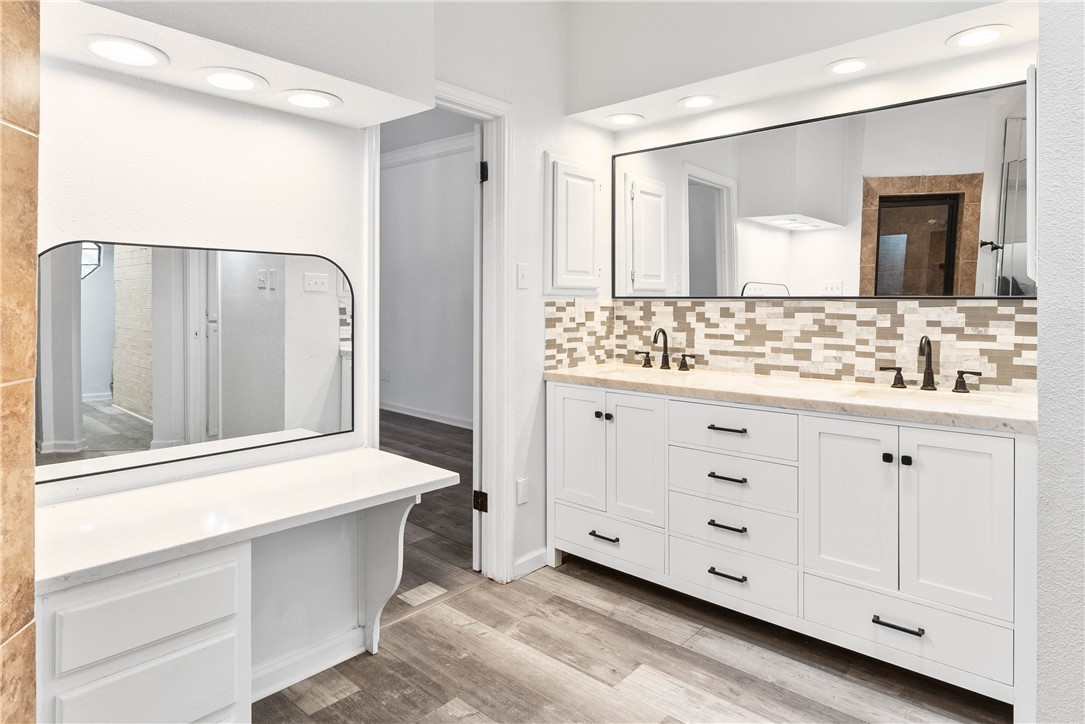 7009 Bevington Drive Corpus Christi, TX 78413 - Photo 19 of 34 a bathroom with a double vanity sink a mirror and a bathtub
