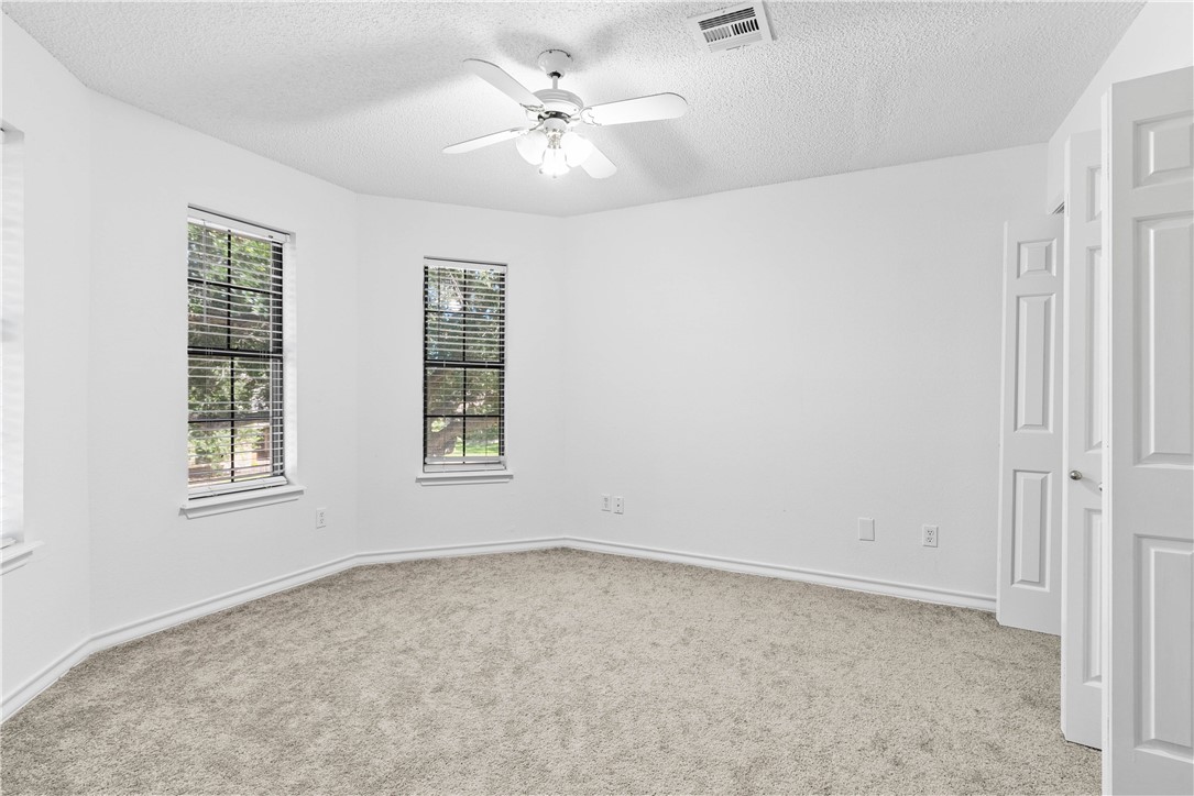 7009 Bevington Drive Corpus Christi, TX 78413 - Photo 28 of 34 an empty room with windows and ceiling fan