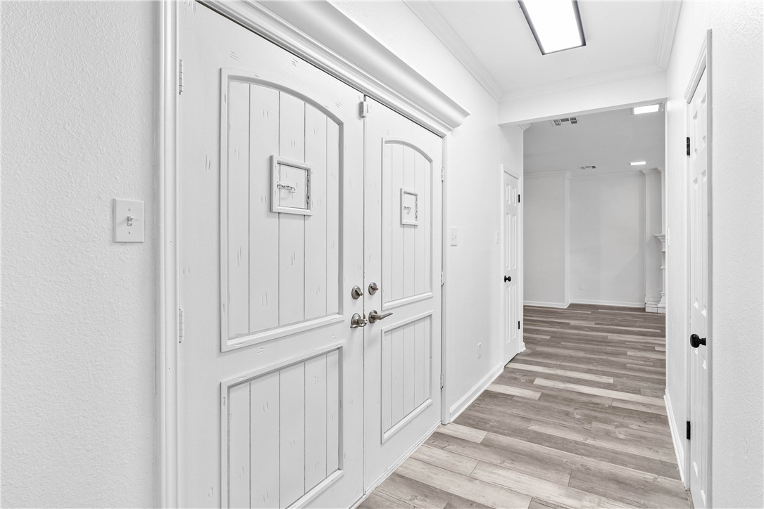 7009 Bevington Drive Corpus Christi, TX 78413 - Photo 3 of 34 a view of a hallway with wooden floor and closet area