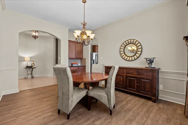 a view of a dining room with furniture a chandelier and wooden floor