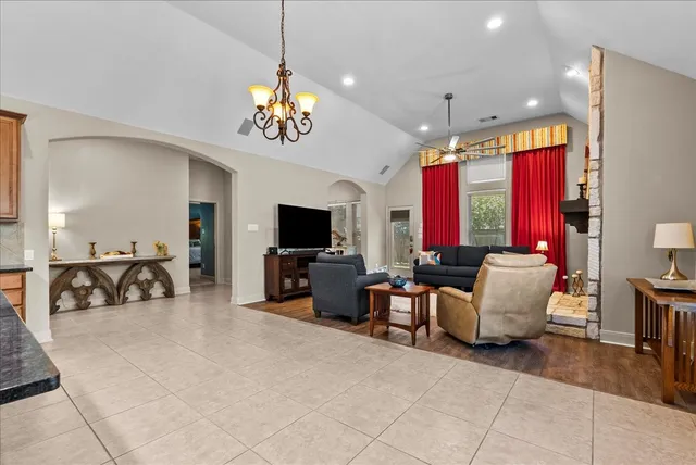 a living room with furniture a flat screen tv and a chandelier
