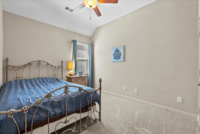 a bedroom with a bed and a painting on the wall