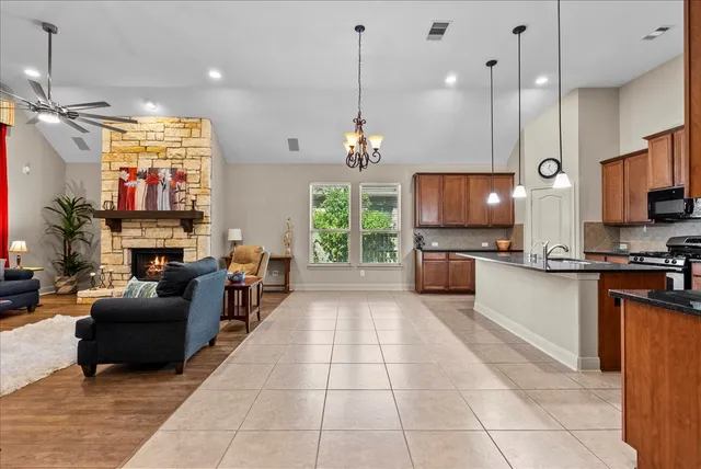 a large kitchen with stainless steel appliances granite countertop a stove a sink dishwasher and a microwave with the open kitchen view