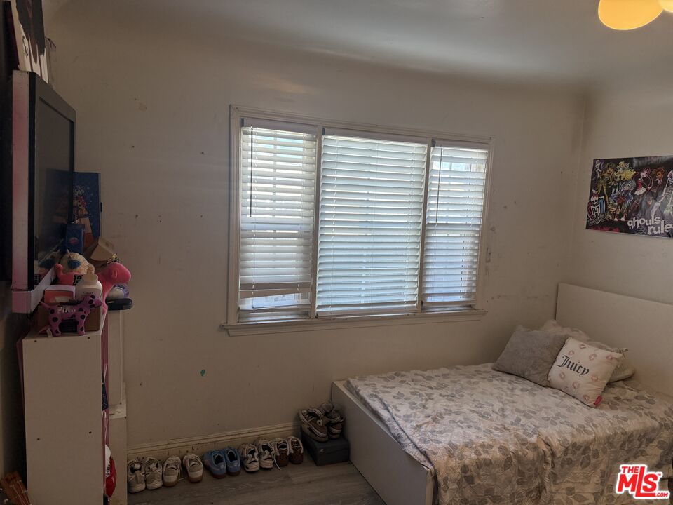 1218 North Spring Avenue Compton, CA 90221 - Photo 7 of 16 a bedroom with a bed and wooden floor