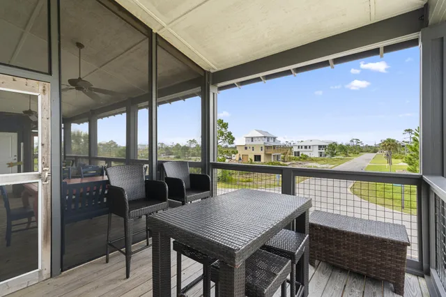 a living room with furniture and a dining table with painting on the wall