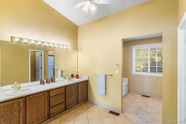 a bathroom with a double vanity sink a mirror and a bathtub