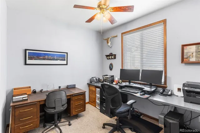 a view of a workspace with furniture and a window