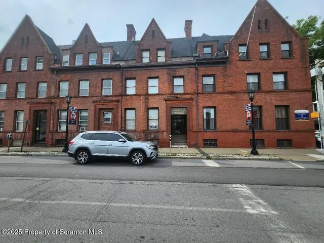 a car parked in front of a big house