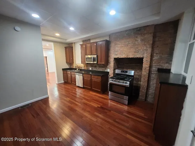 a view of empty room with wooden floor