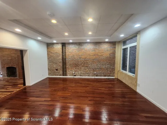 a kitchen with stainless steel appliances a stove a microwave and a hard wood floor