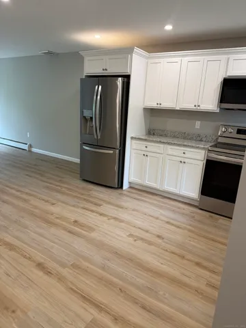 a kitchen with granite countertop a refrigerator stove and sink