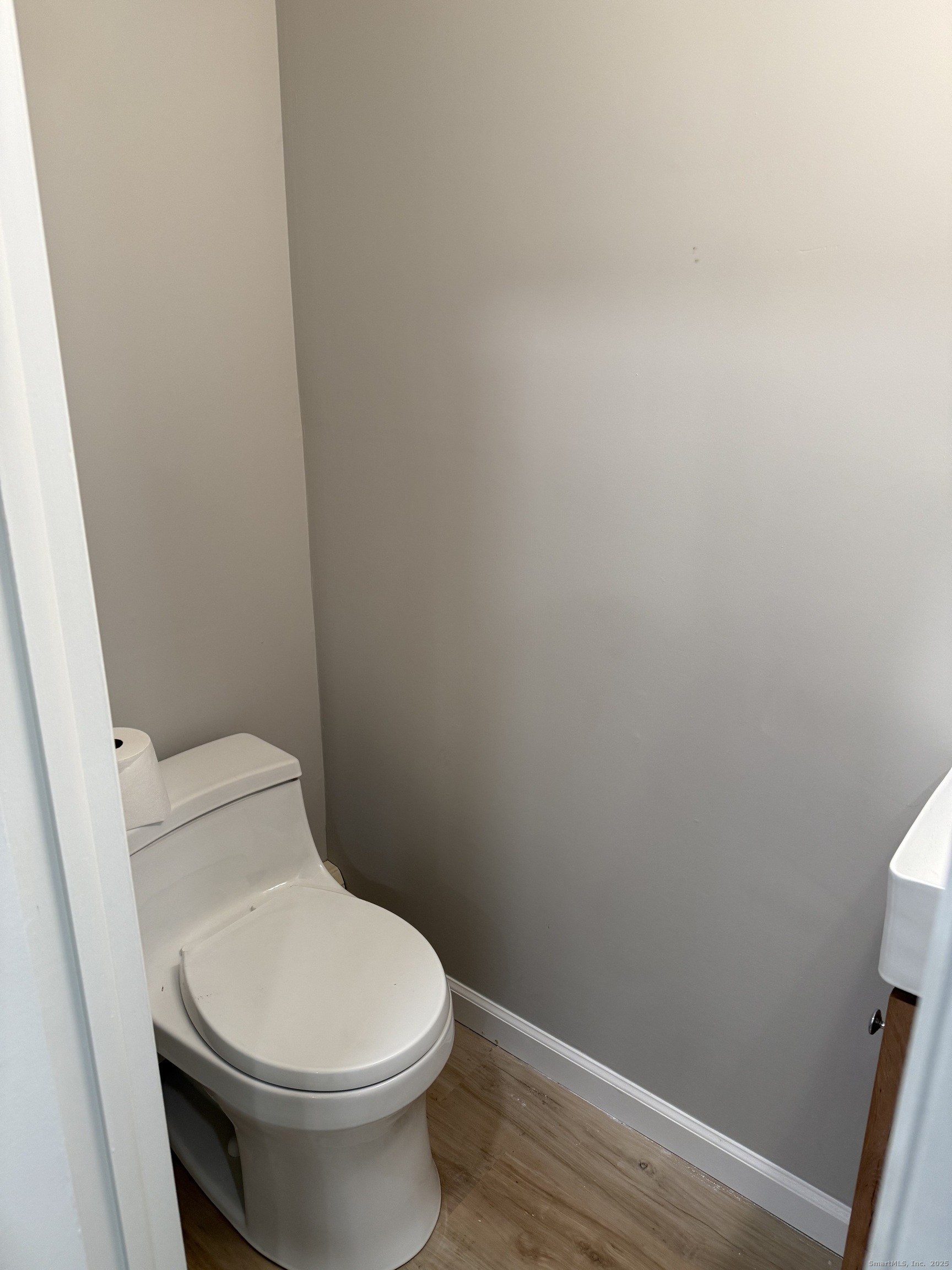 240 Centerbrook Road, Unit 240 Hamden, CT 06518 - Photo 10 of 26 a white toilet sitting next to a wooden cabinet