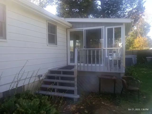 a view of a house with a small yard and wooden floor and fence