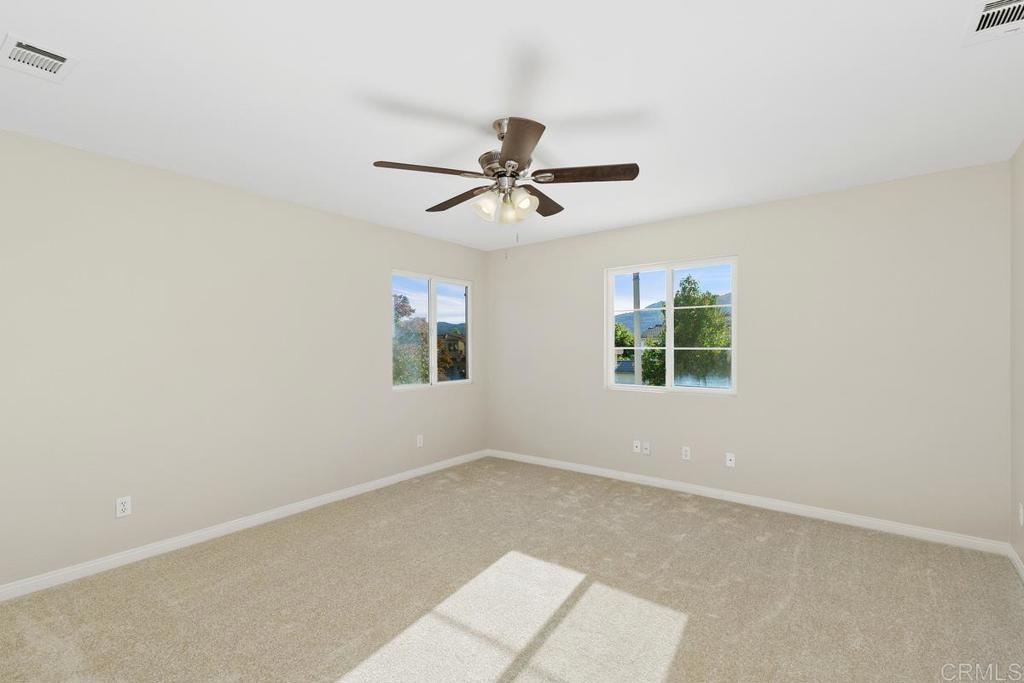 46056 Paseo Gallante Temecula, CA 92592 - Photo 23 of 41 an empty room with windows and chandelier fan