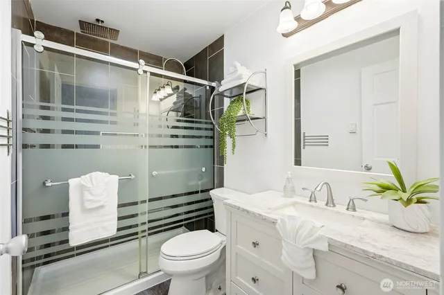 a bathroom with a sink a toilet and shower