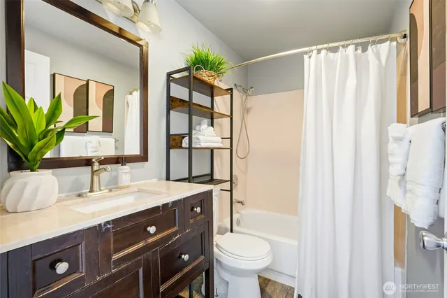 a bathroom with a granite countertop sink toilet and shower