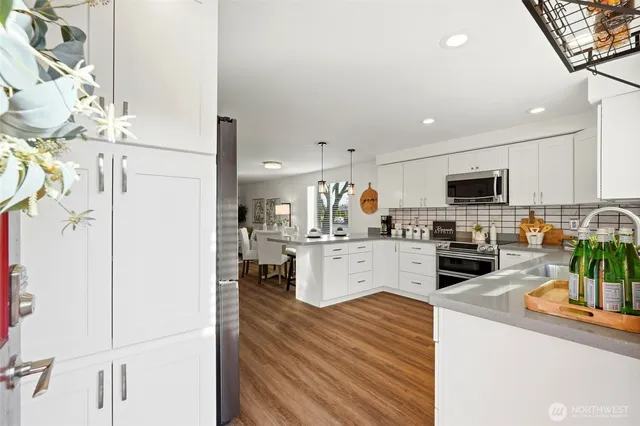 a kitchen with stainless steel appliances a refrigerator sink and white cabinets
