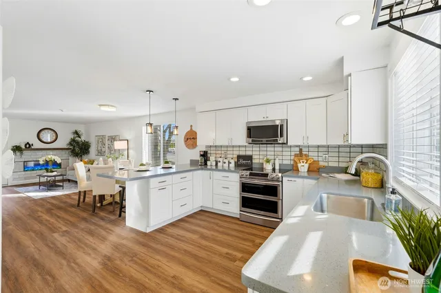 a kitchen that has a lot of cabinets a sink and appliances in it
